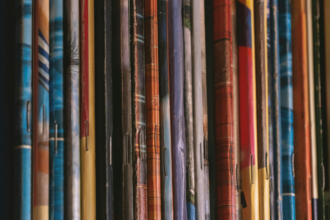 The spines of a row of magazines on a shelf.